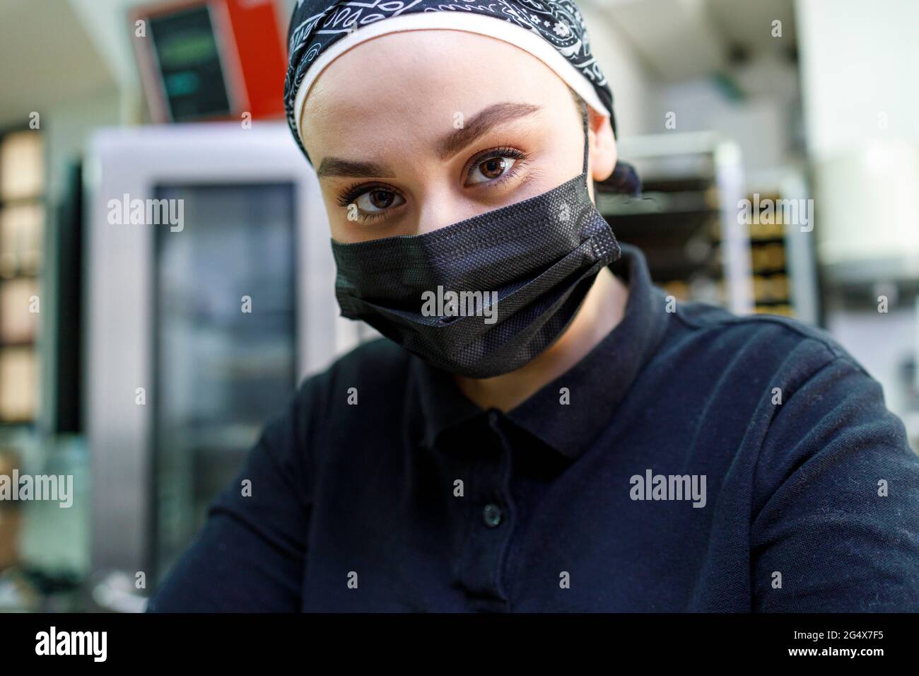 Female owner with protective face mask in bakery Stock Photo