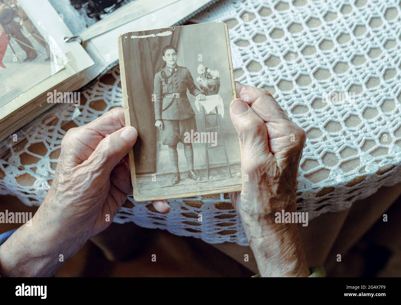 Senior woman remembering past while watching old photograph at home Stock Photo