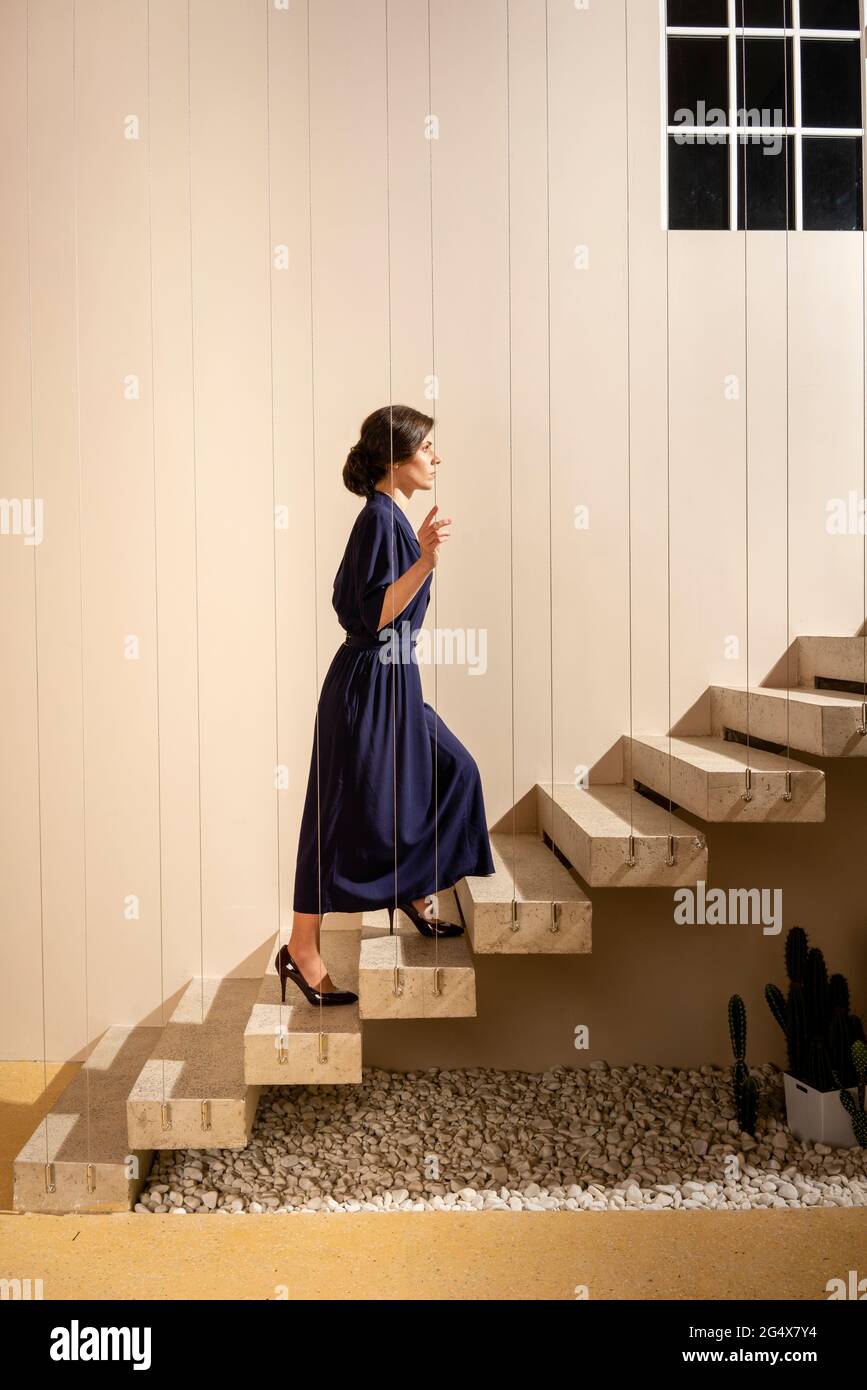 Woman moving up on staircase Stock Photo