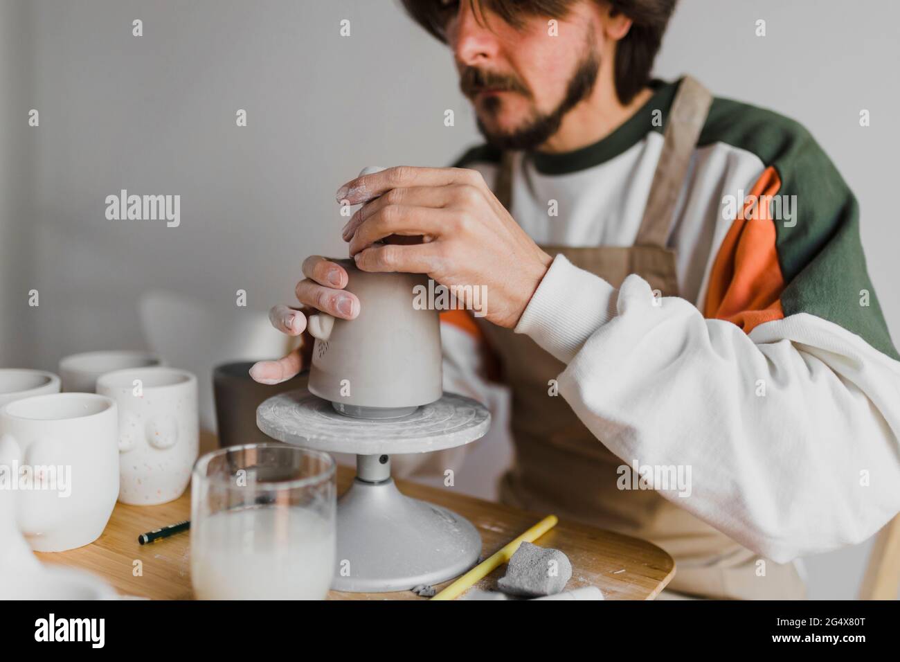 Male expert molding clay on pottery wheel at workplace Stock Photo Alamy