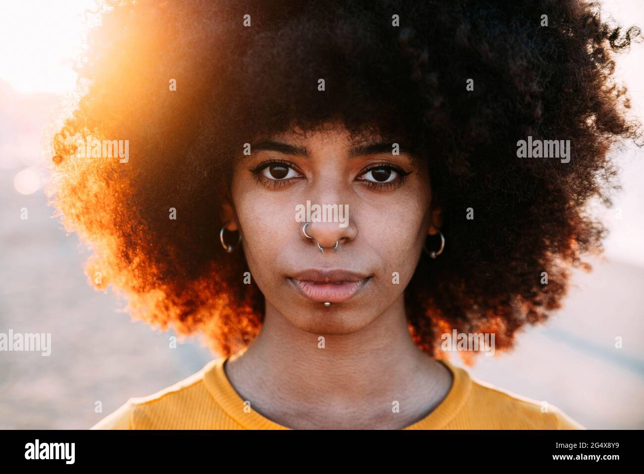 Afro woman with pierced nose during sunset Stock Photo
