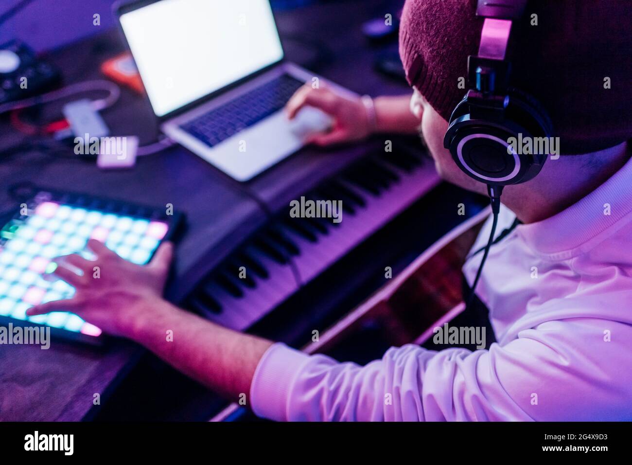 Male composer wearing headphones composing music at home studio Stock Photo