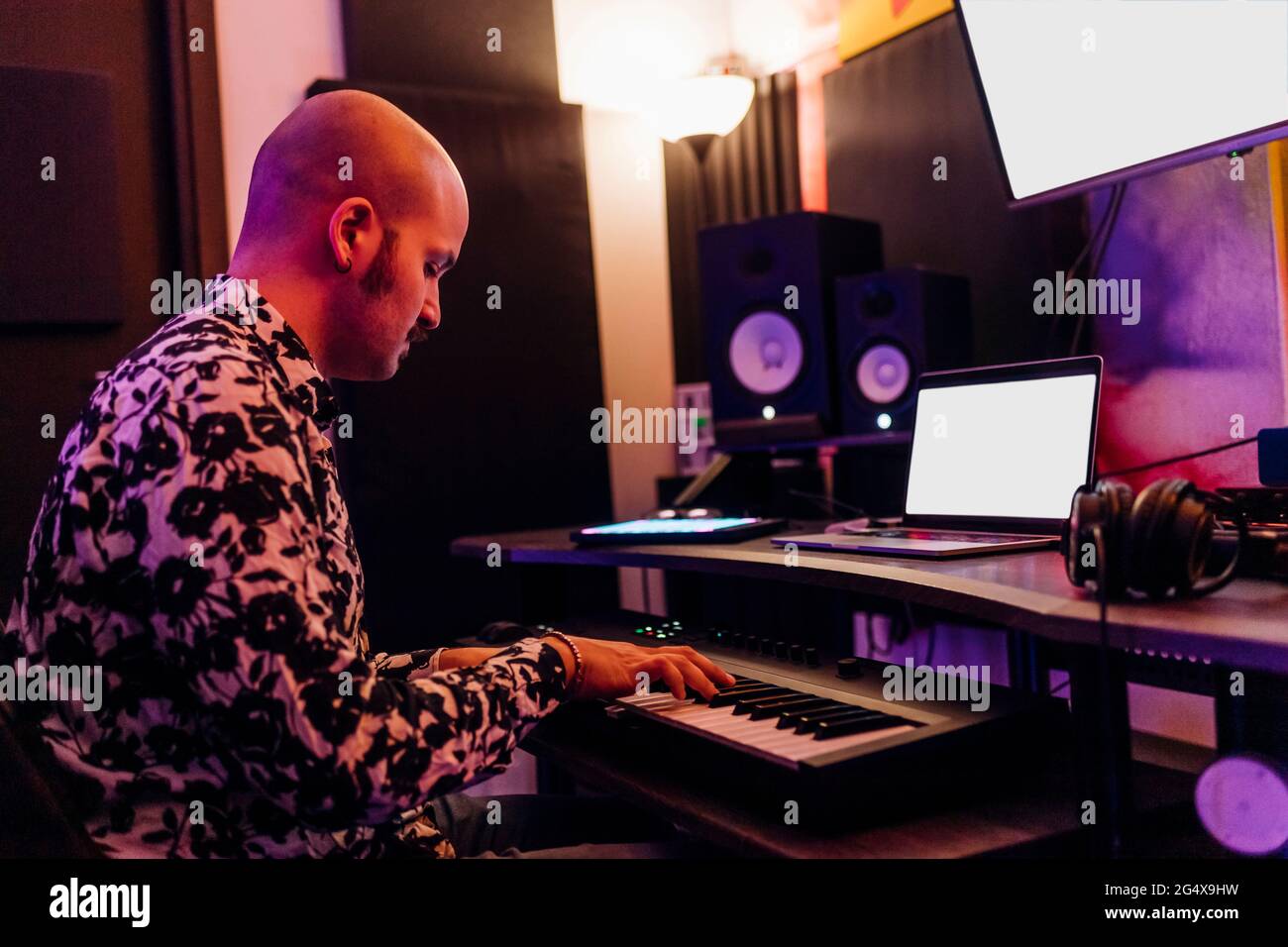Man playing piano while composing music in studio Stock Photo