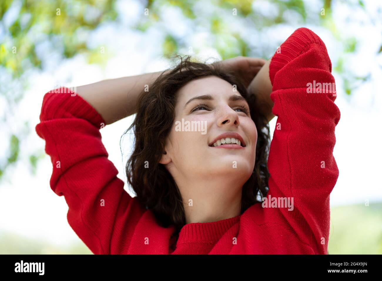 Woman smiling hands behind head hi-res stock photography and images - Alamy
