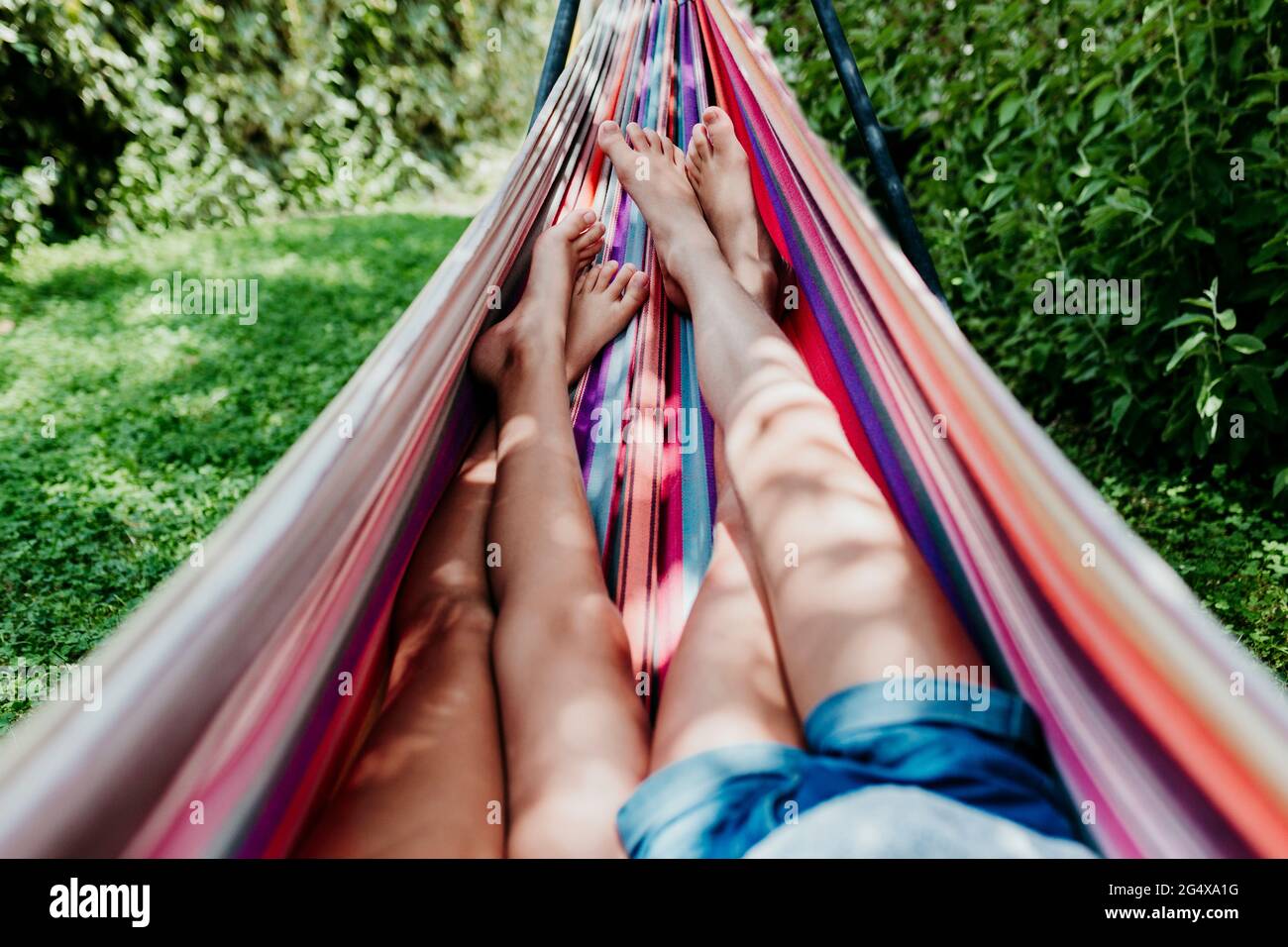 Girls lying in hammock on sunny day Stock Photo