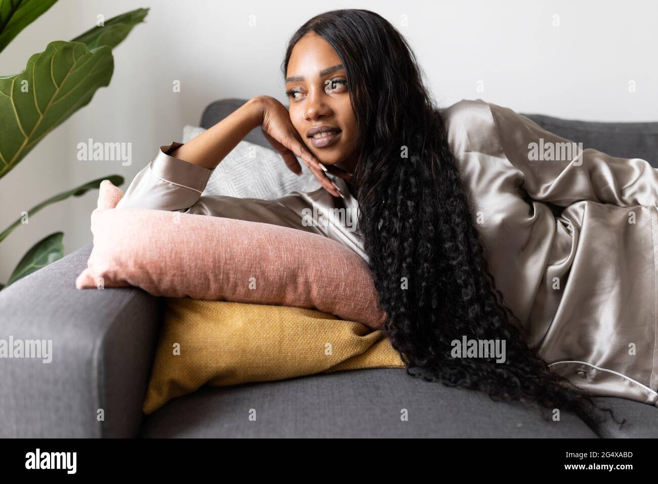 Woman With Long Black Hair Lying On Sofa While Day Dreaming At Home Stock Photo Alamy