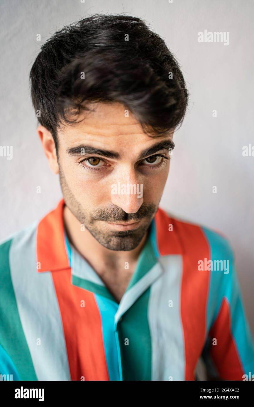 Young man in striped multi colored shirt Stock Photo