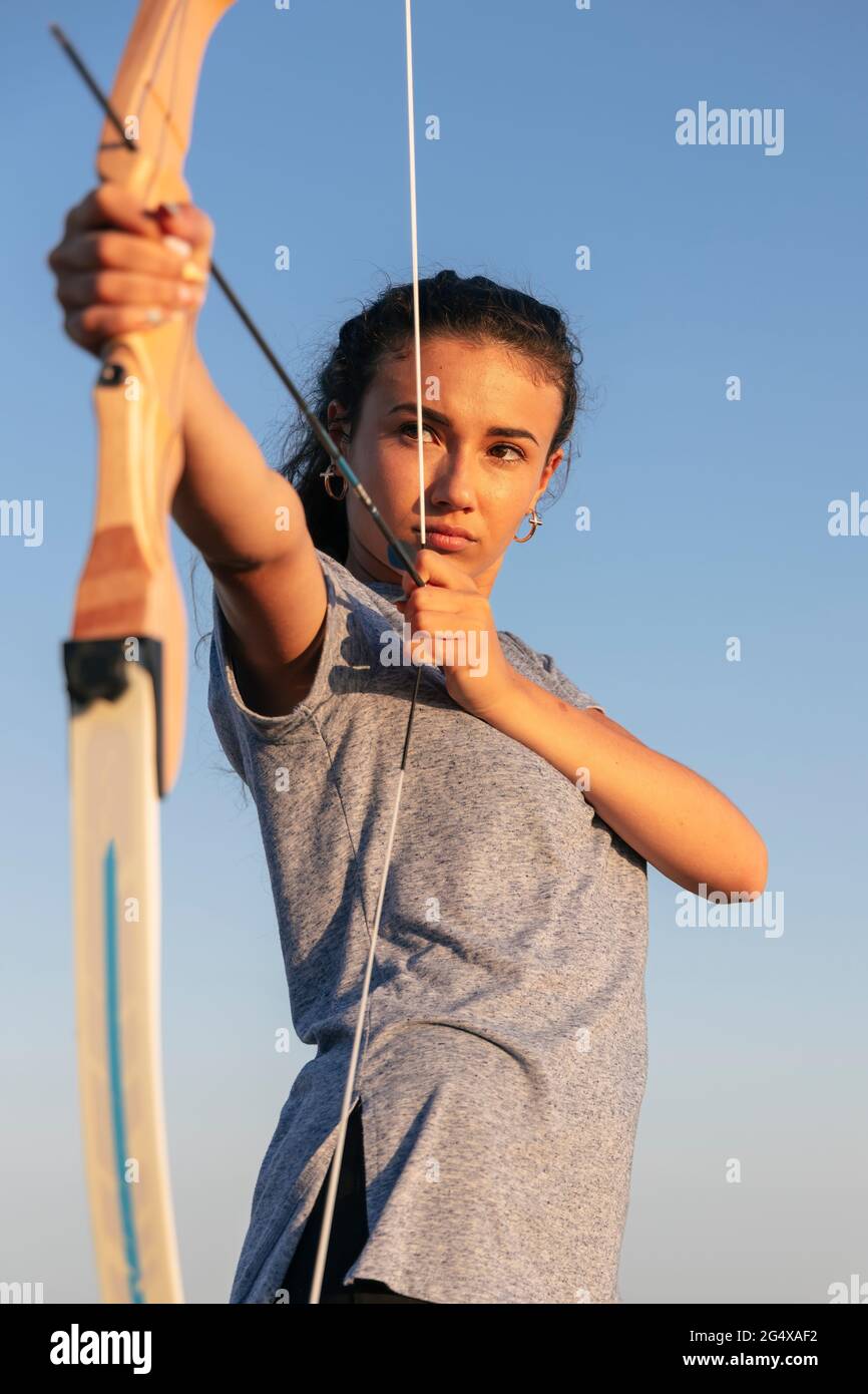 Archeress aiming with bow and arrow Stock Photo Alamy