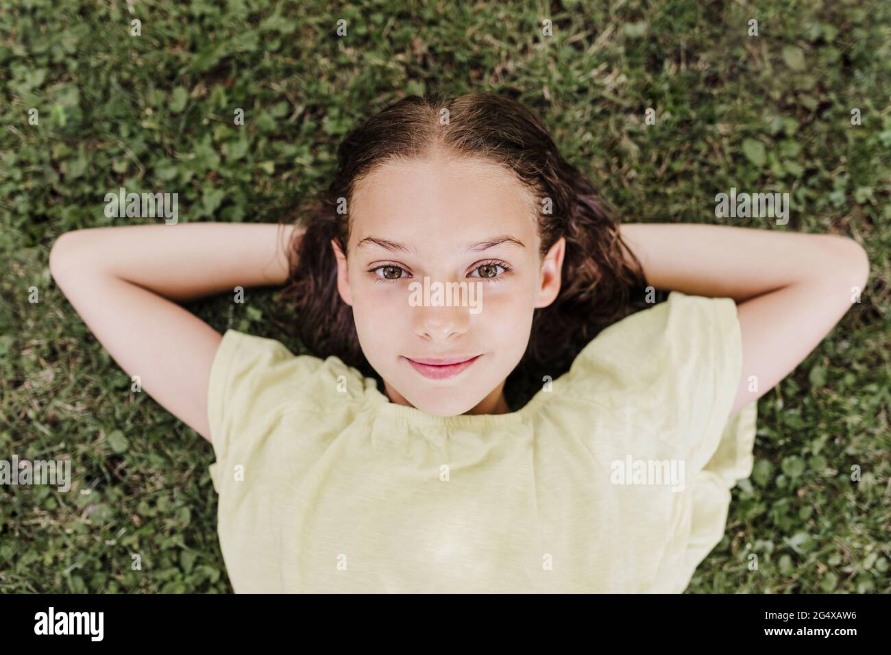 Smiling girl lying on grass in summer Stock Photo