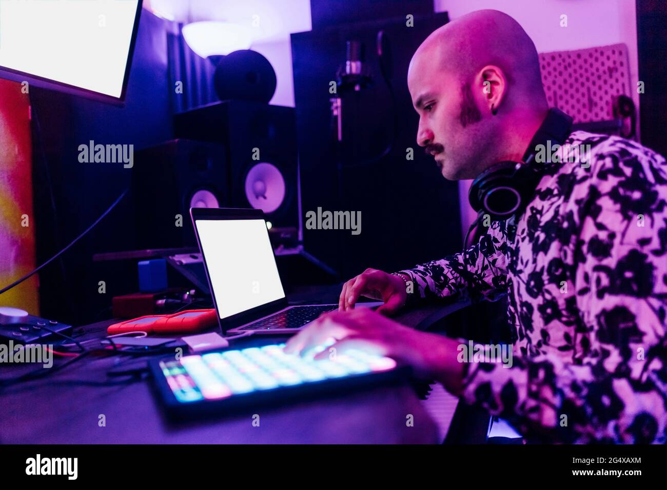 Male music composer using laptop at home studio Stock Photo