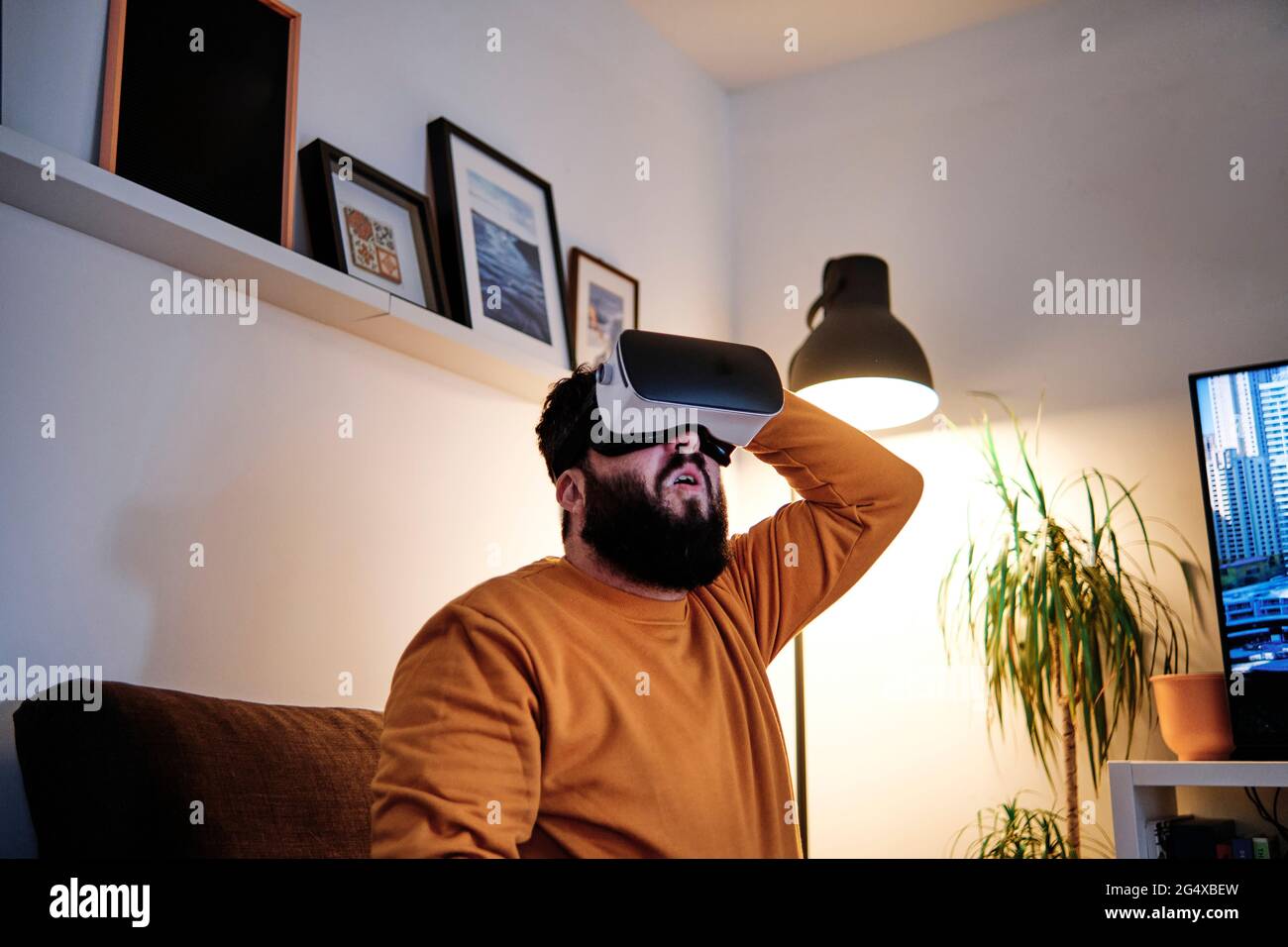 Matured man using virtual reality simulator at home Stock Photo
