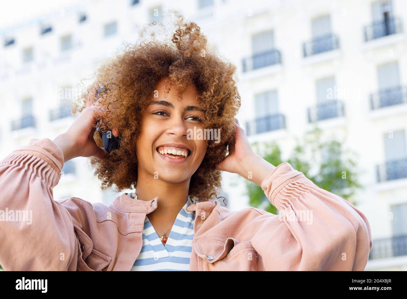 Curly woman adjusting hair hi-res stock photography and images - Alamy