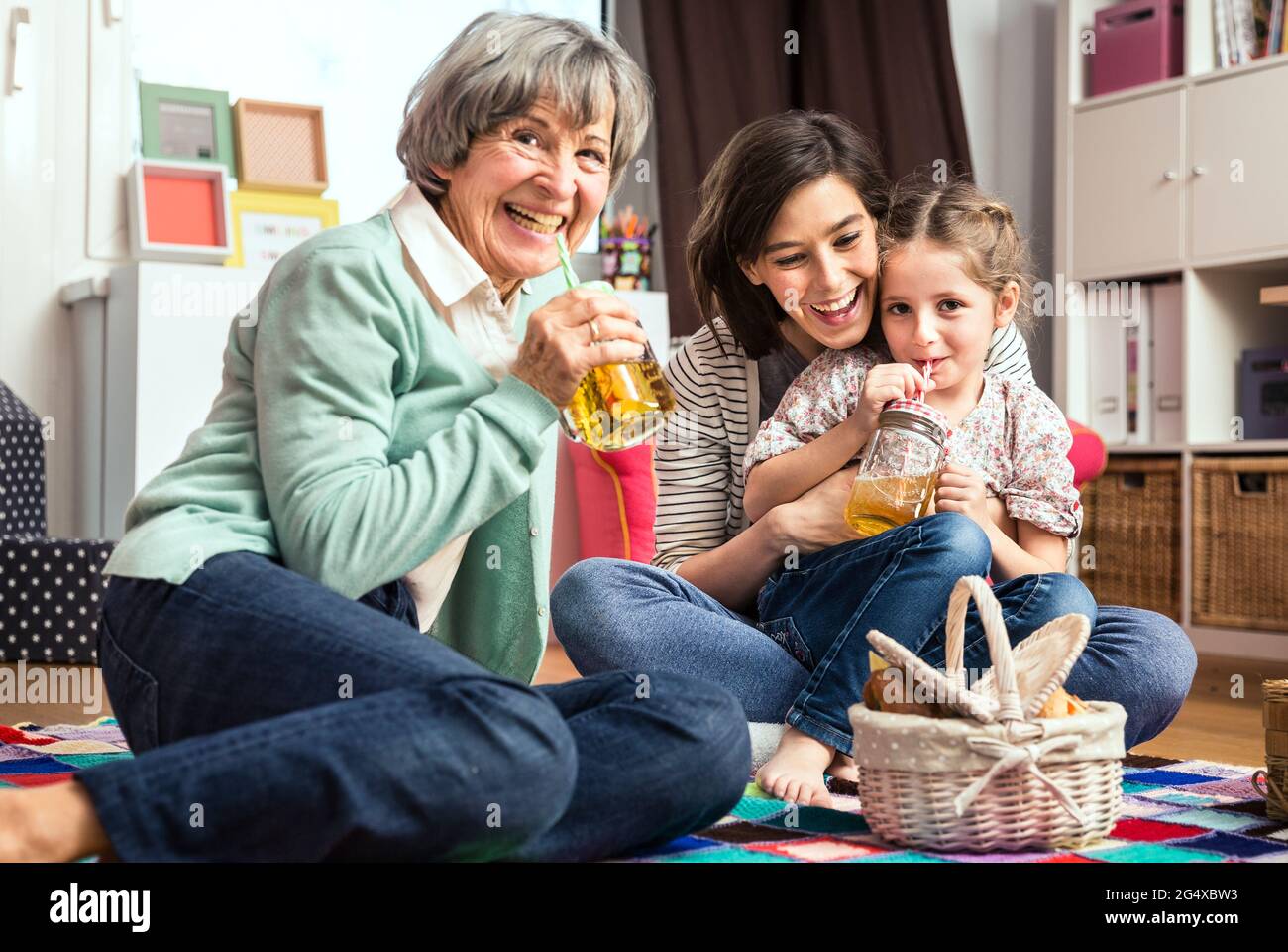 Multi-generation family playing picnic in nursery Stock Photo