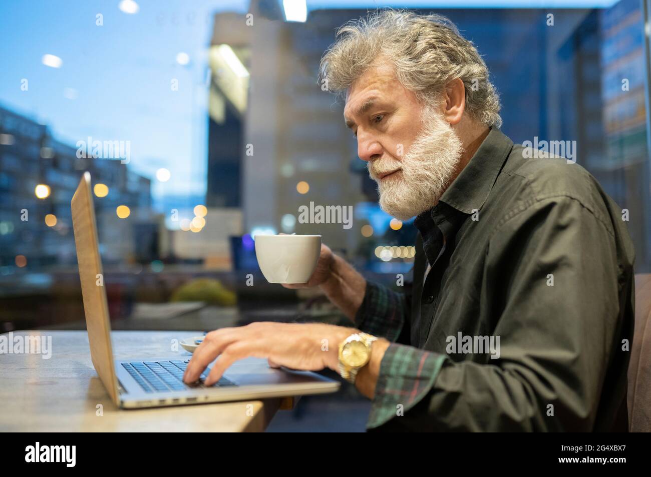 Businessman using laptop while working in cafe Stock Photo