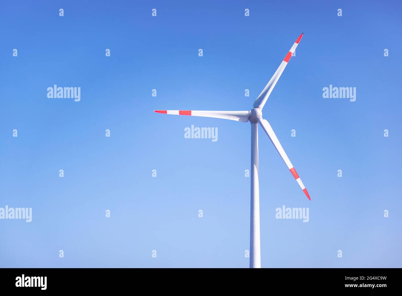 Wind turbine standing against clear blue sky Stock Photo - Alamy