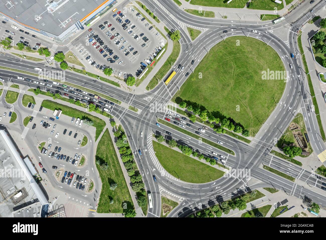 road intersection with roundabout in the city. cars traffic at sunny summer day. aerial top view. Stock Photo
