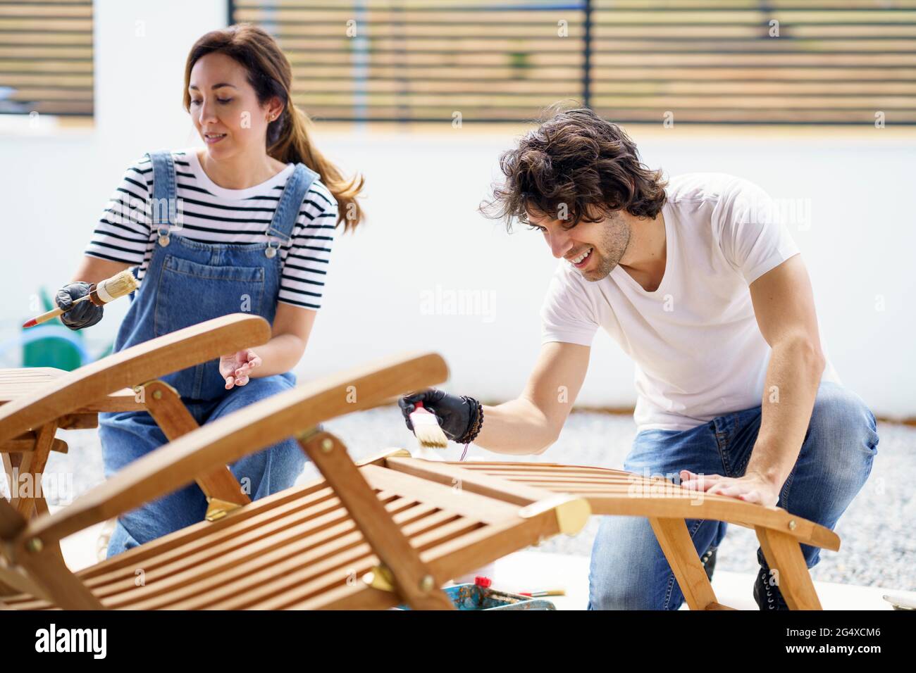 Couple polishing lounge chair together Stock Photo