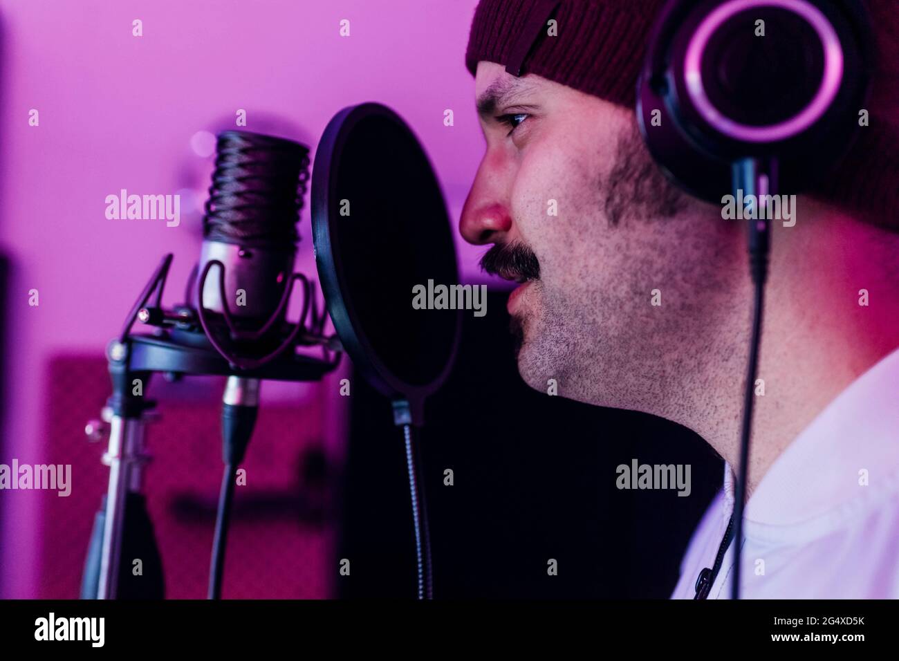 Male singer looking away while singing at studio Stock Photo