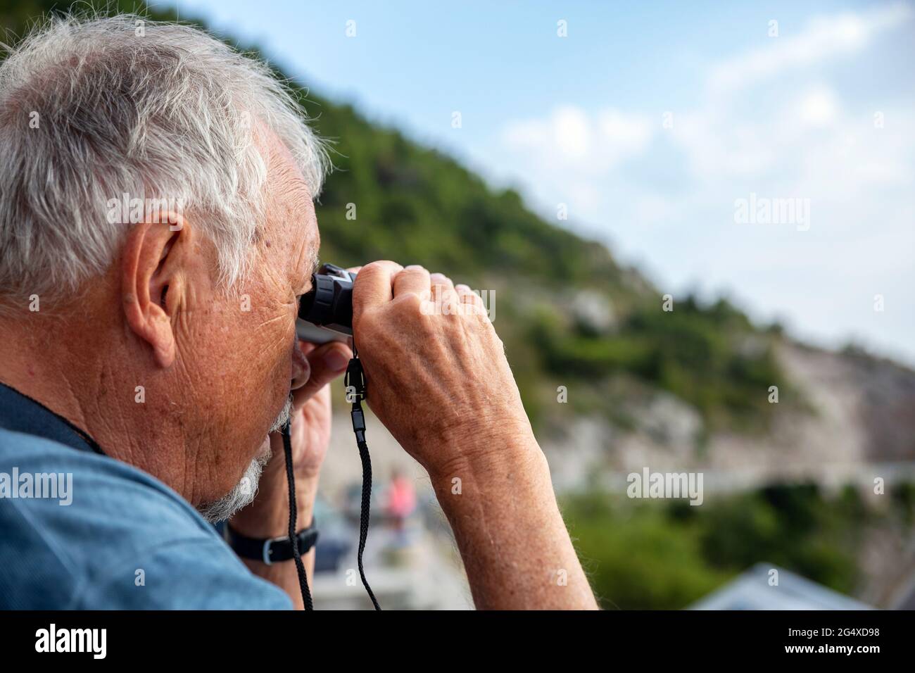 Senior man looking through binoculars Stock Photo