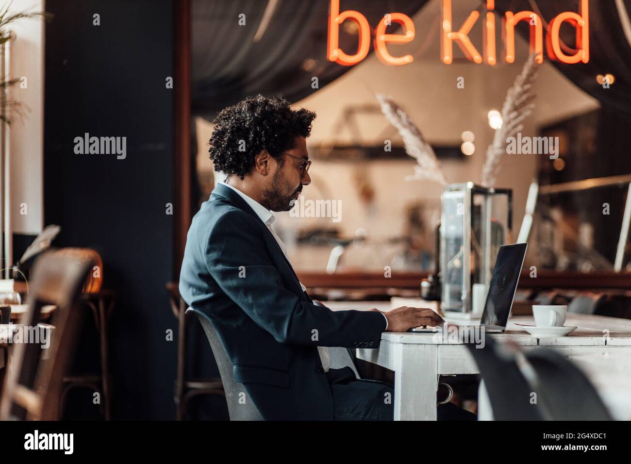 Male professional typing on laptop while working in cafe Stock Photo
