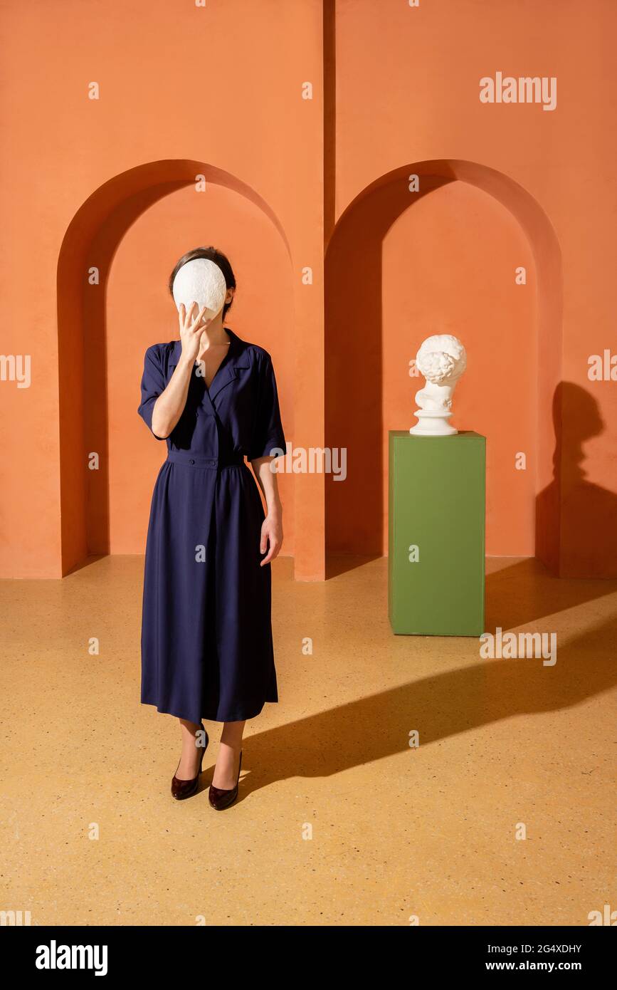 Woman covering face with mask Stock Photo