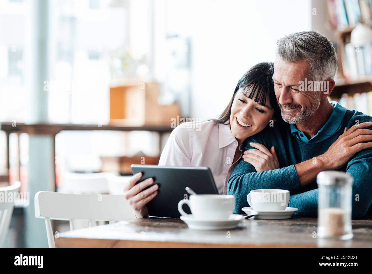 Business couple smiling while using digital tablet at cafe Stock Photo