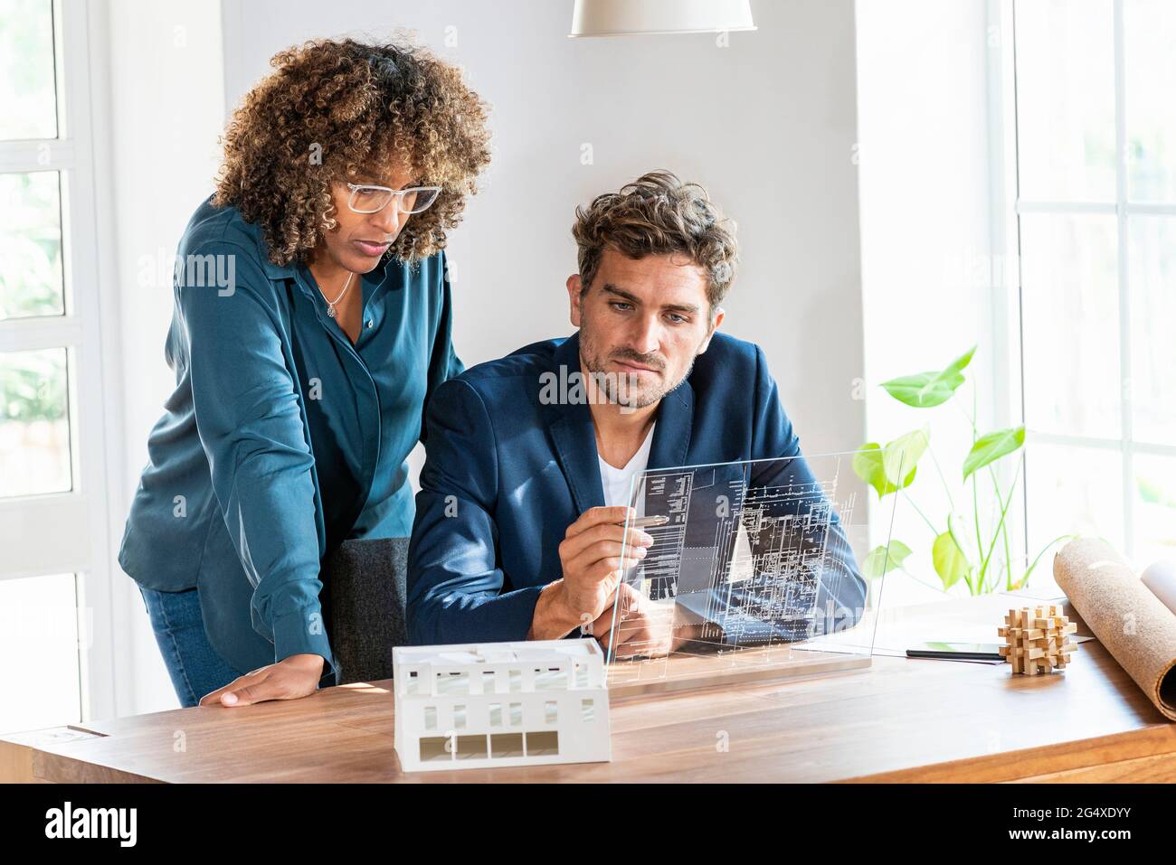 Male and female architects working on futuristic digital tablet at office Stock Photo