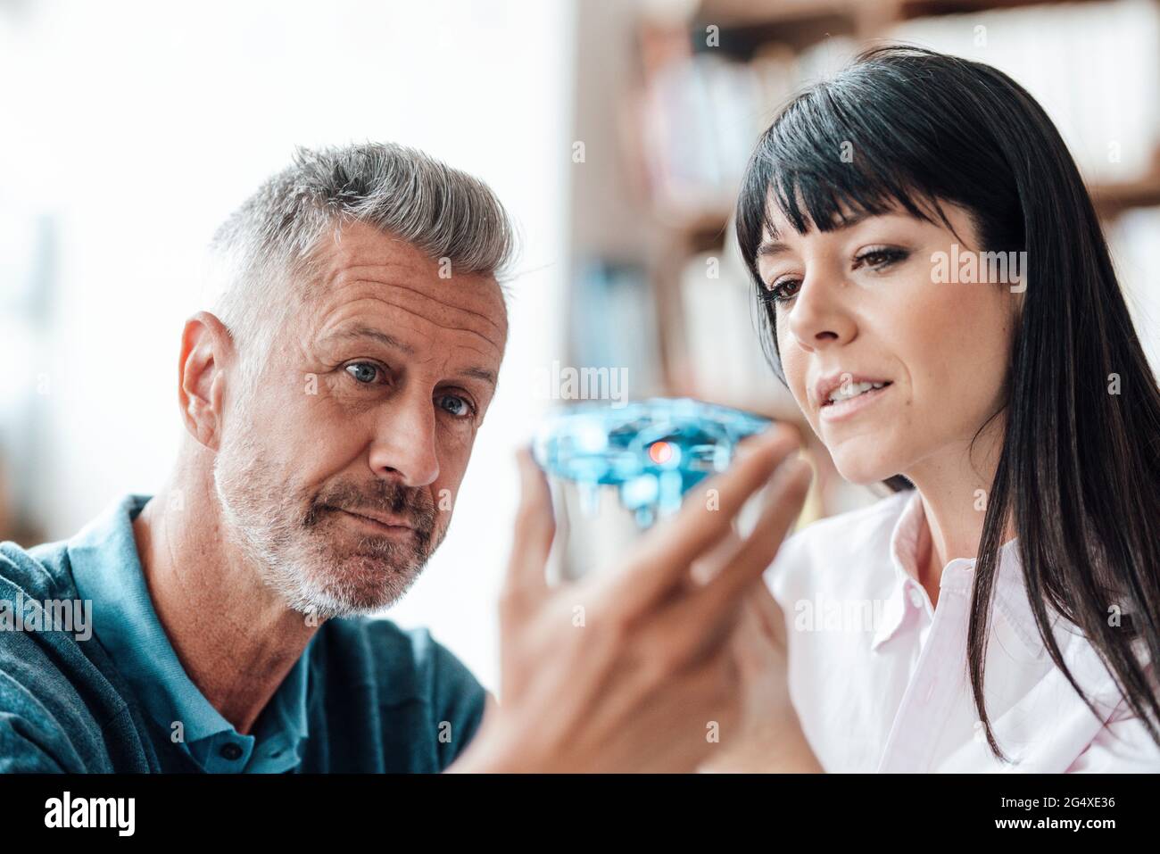 Colleagues checking drone while working at cafe Stock Photo