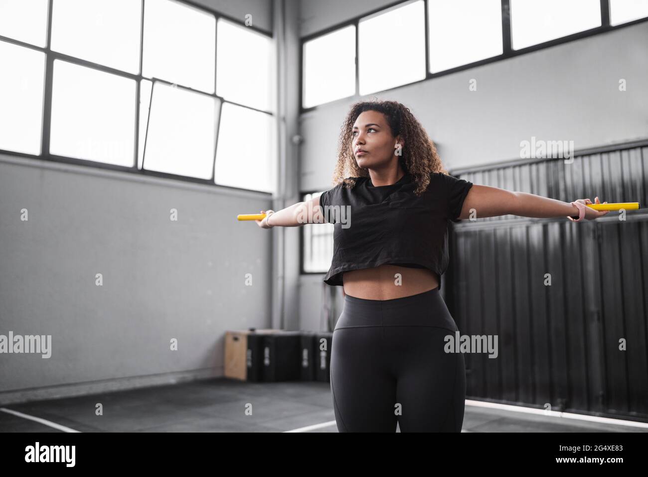 Young woman looking away while exercising in gym Stock Photo - Alamy