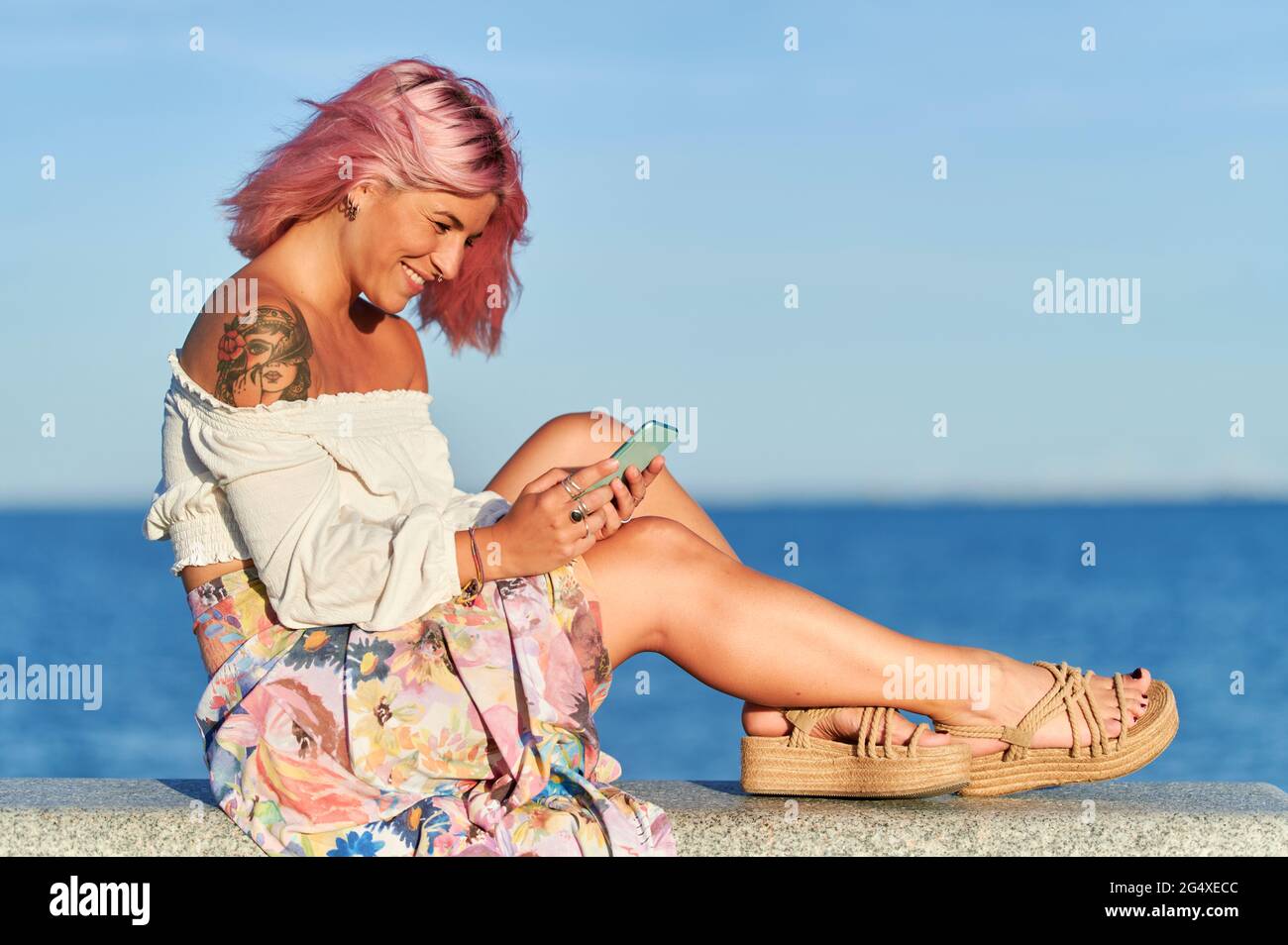 Woman sitting wall sea sky day hi-res stock photography and images - Alamy