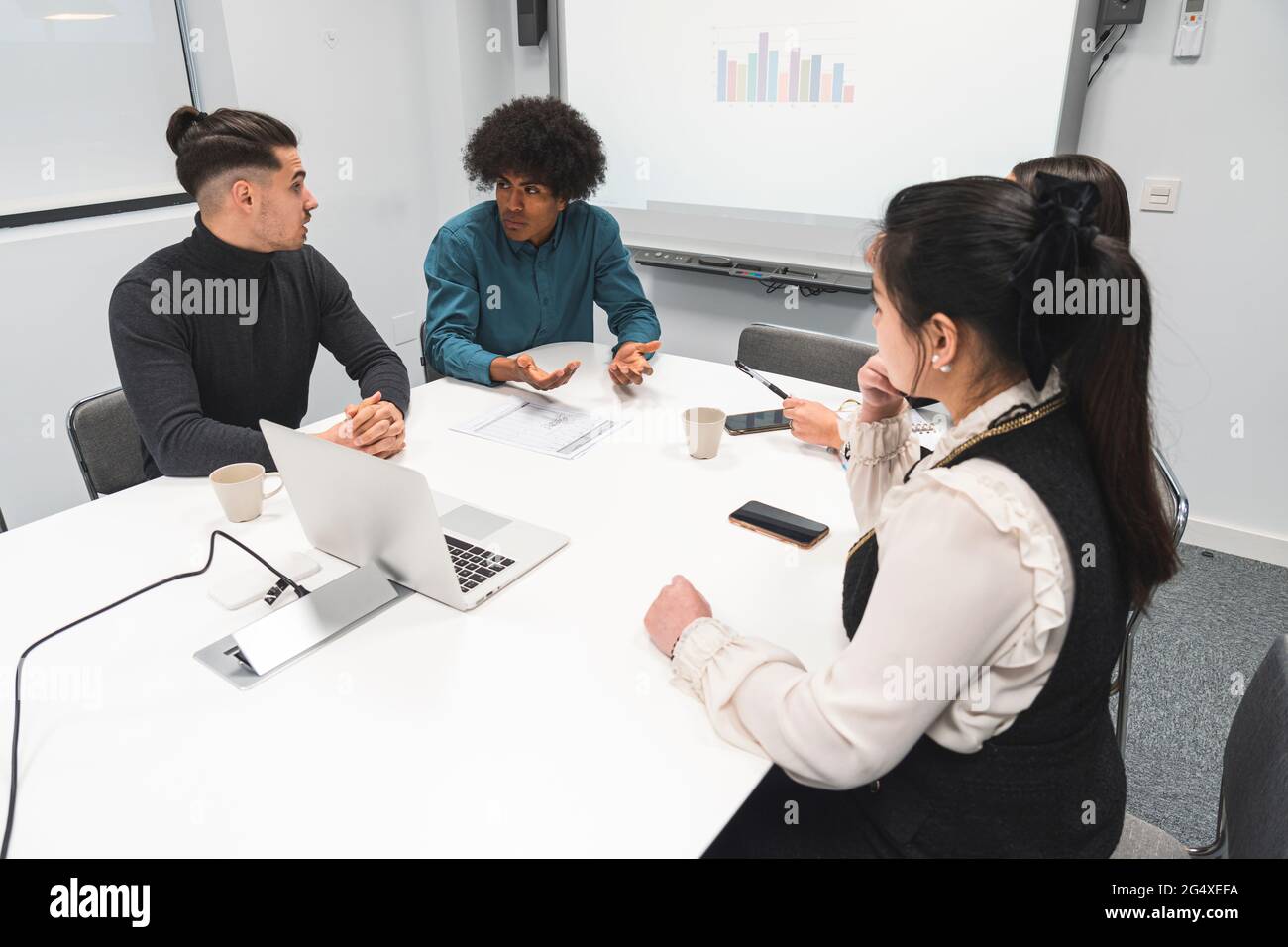 Multi-ethnic male and female entrepreneurs discussing at office Stock Photo