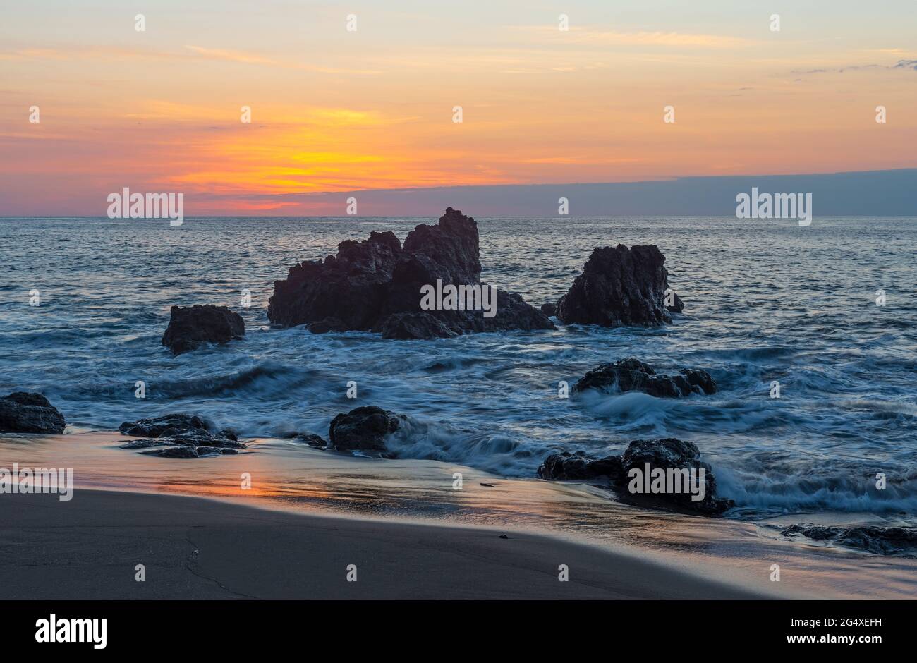 Corcovado national park beach at sunset with rocks by Pacific Ocean, Osa Peninsula, Costa Rica. Stock Photo