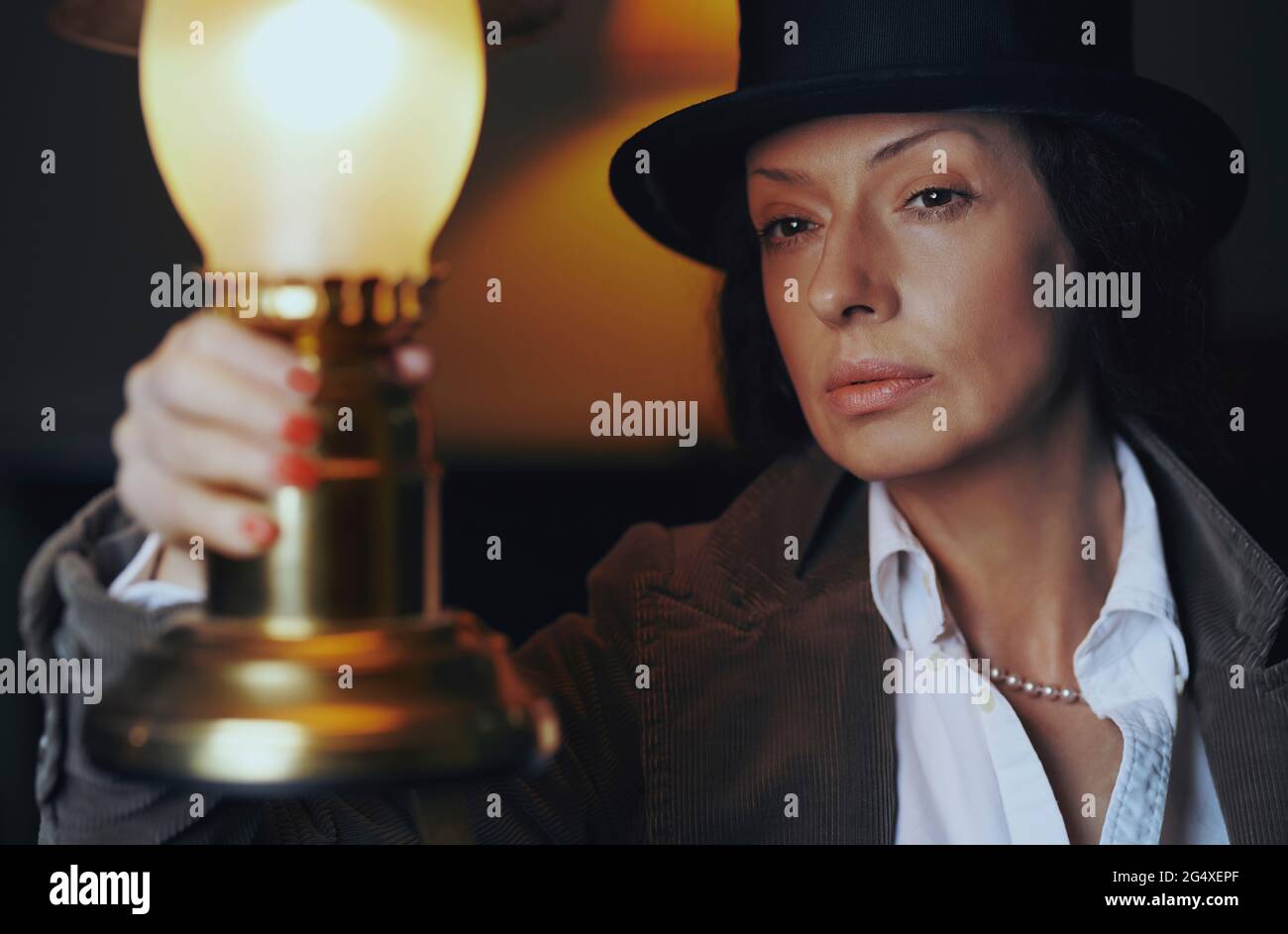 Mature woman holding old-fashioned electric lamp Stock Photo