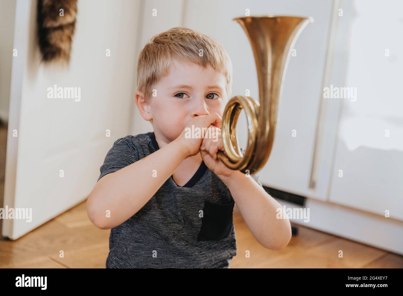 Boy playing tuba while sitting at home Stock Photo Alamy