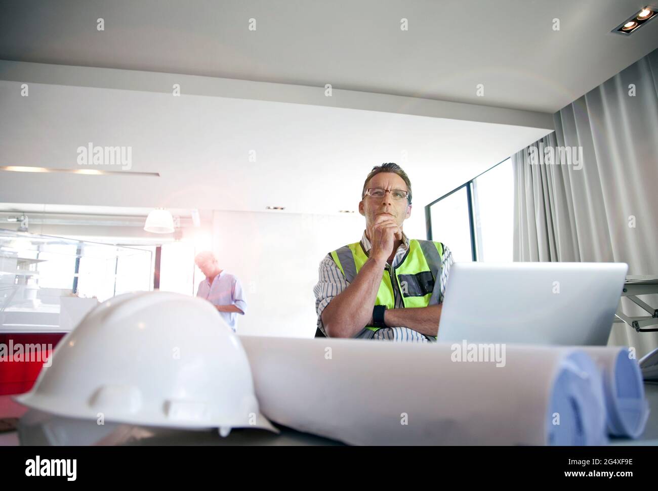 Thoughtful architect looking away while sitting in office Stock Photo