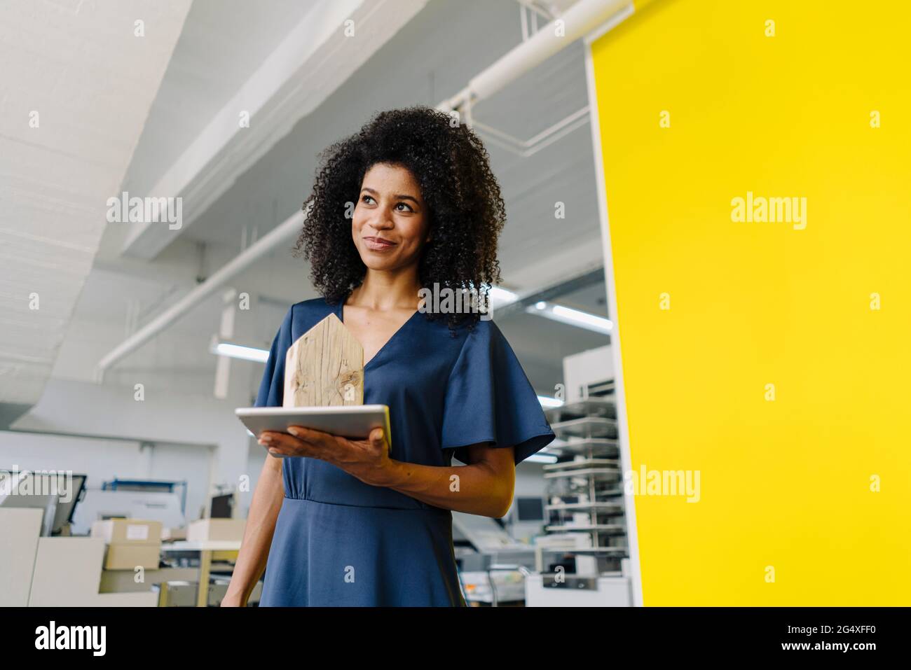 Female real estate agent holding digital tablet and house model in agency Stock Photo