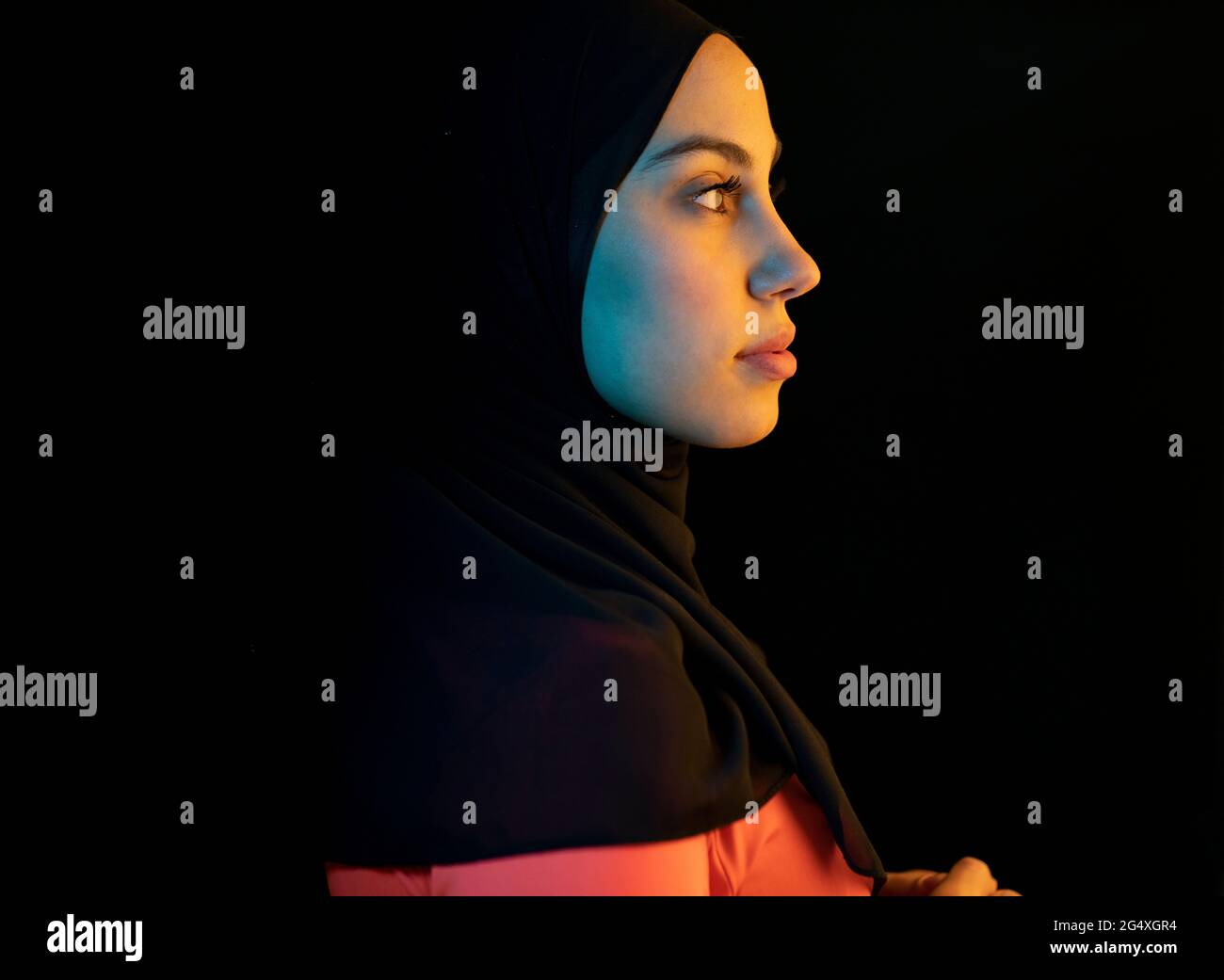 Young Arab woman with headscarf against black background Stock Photo