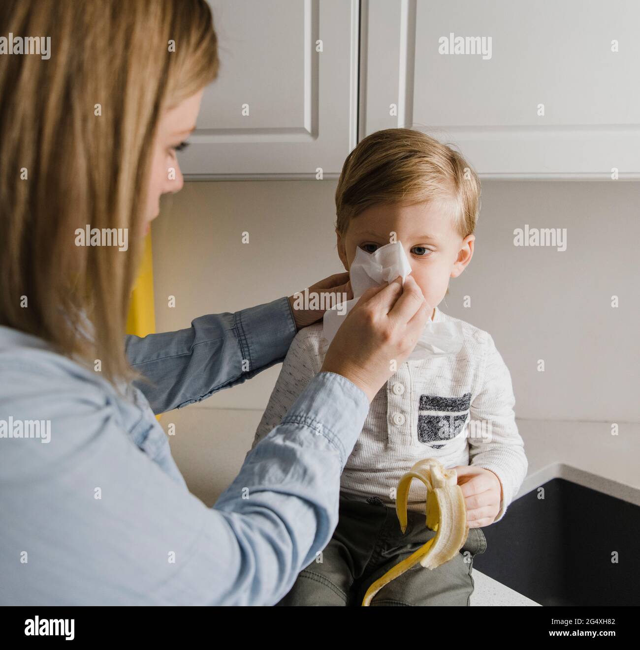 Mother cleaning son's nose at home Stock Photo Alamy