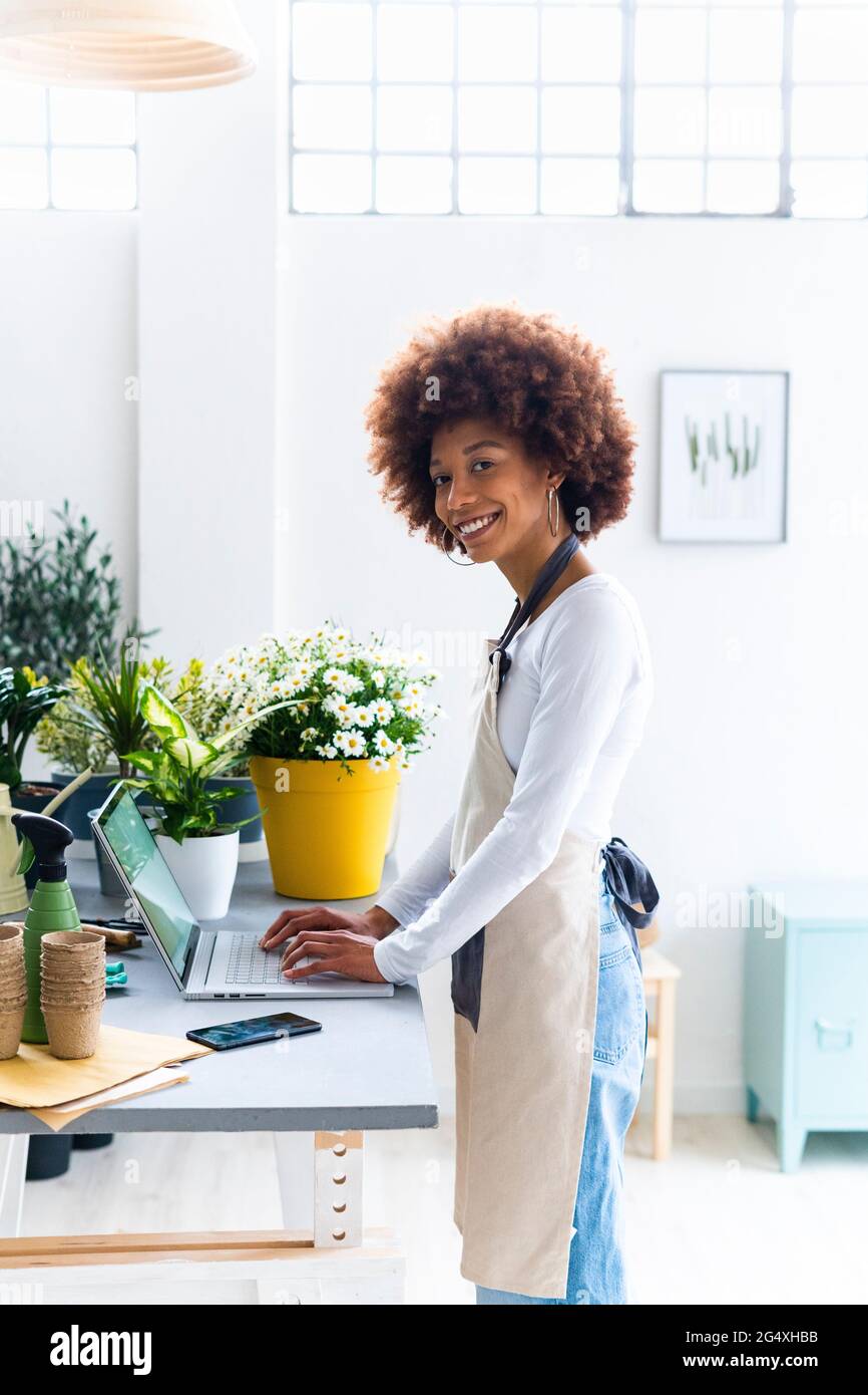 Lady Store Owner Female shop owner with laptop standing at plant store Stock Photo - Alamy