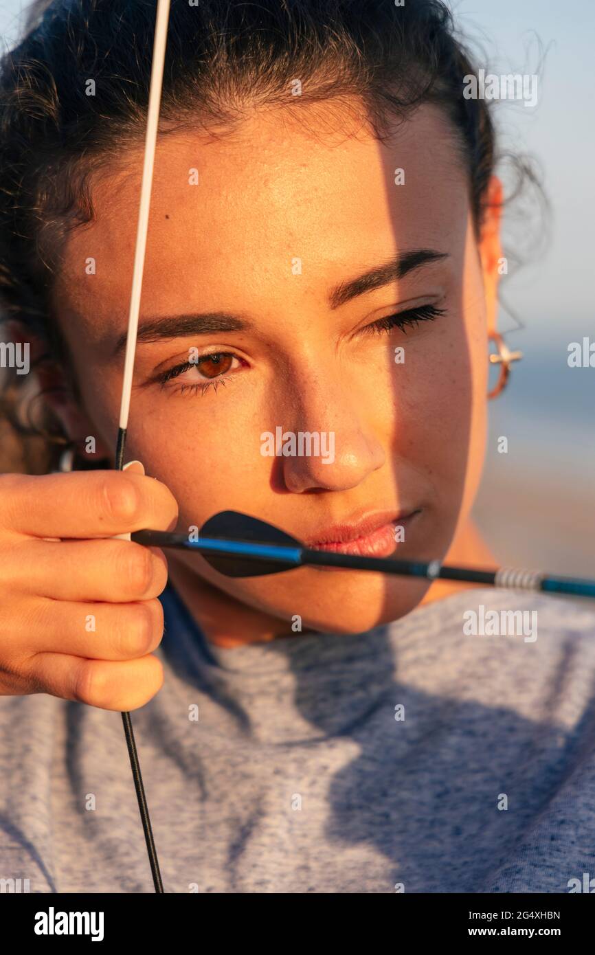 Young determined woman practicing archery Stock Photo