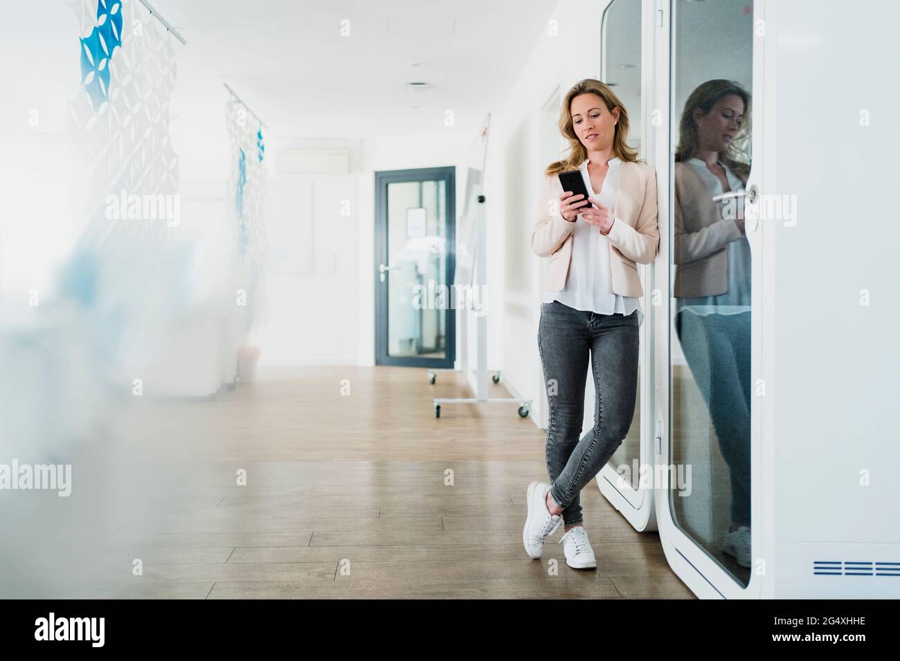 Texting Through Phone Businesswoman texting through mobile phone in office Stock Photo - Alamy