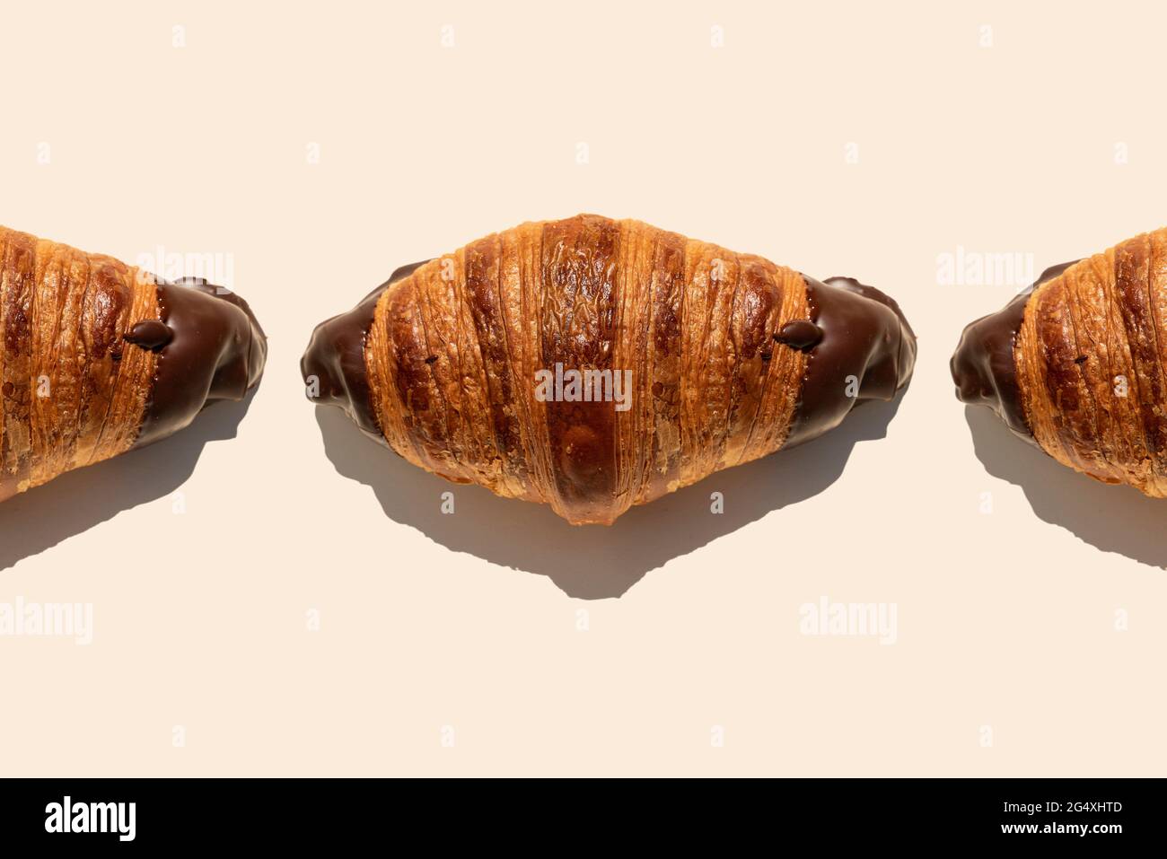 Tempting chocolate croissants on beige background Stock Photo