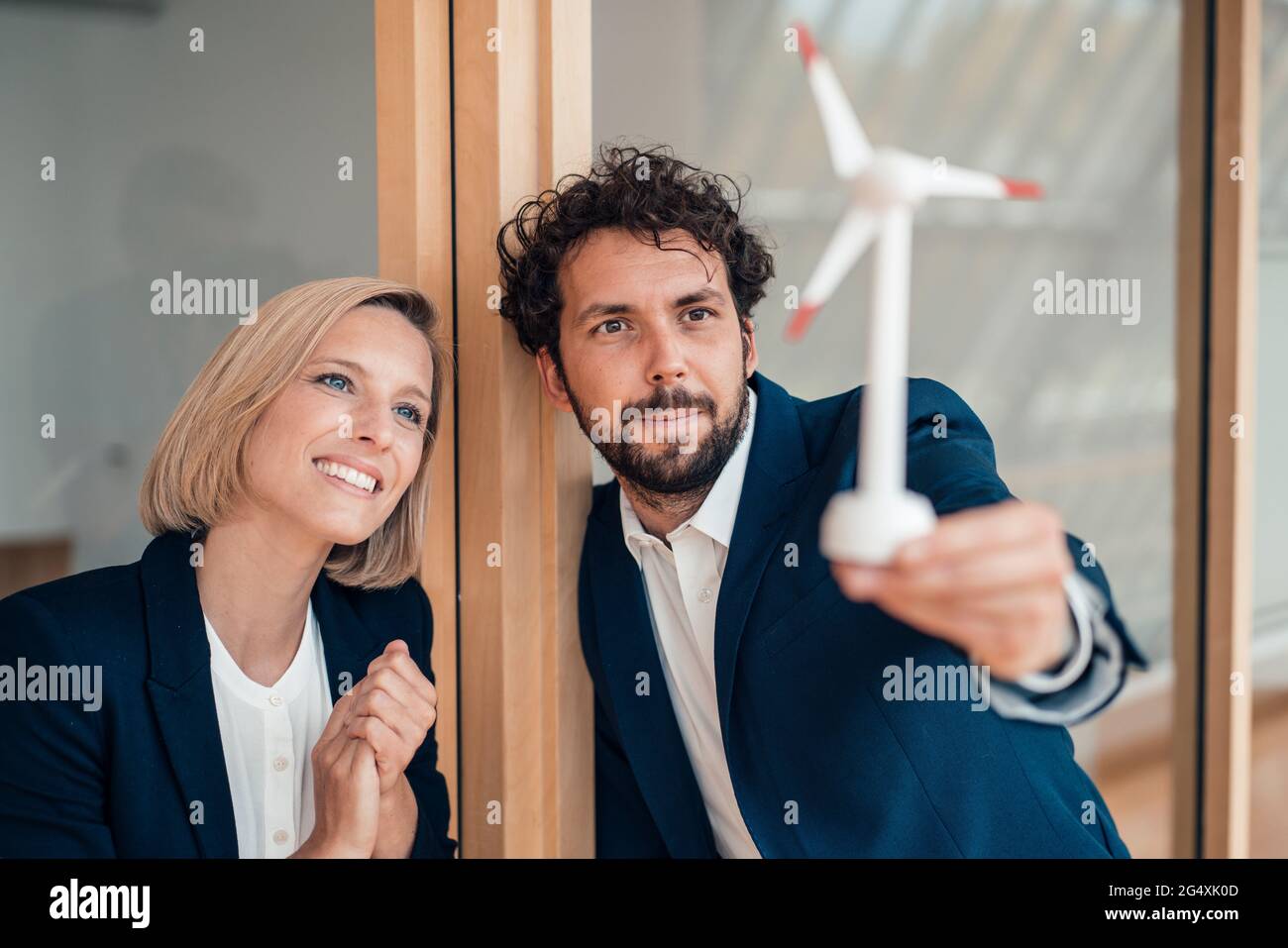 Professional team looking at wind turbine model in office Stock Photo