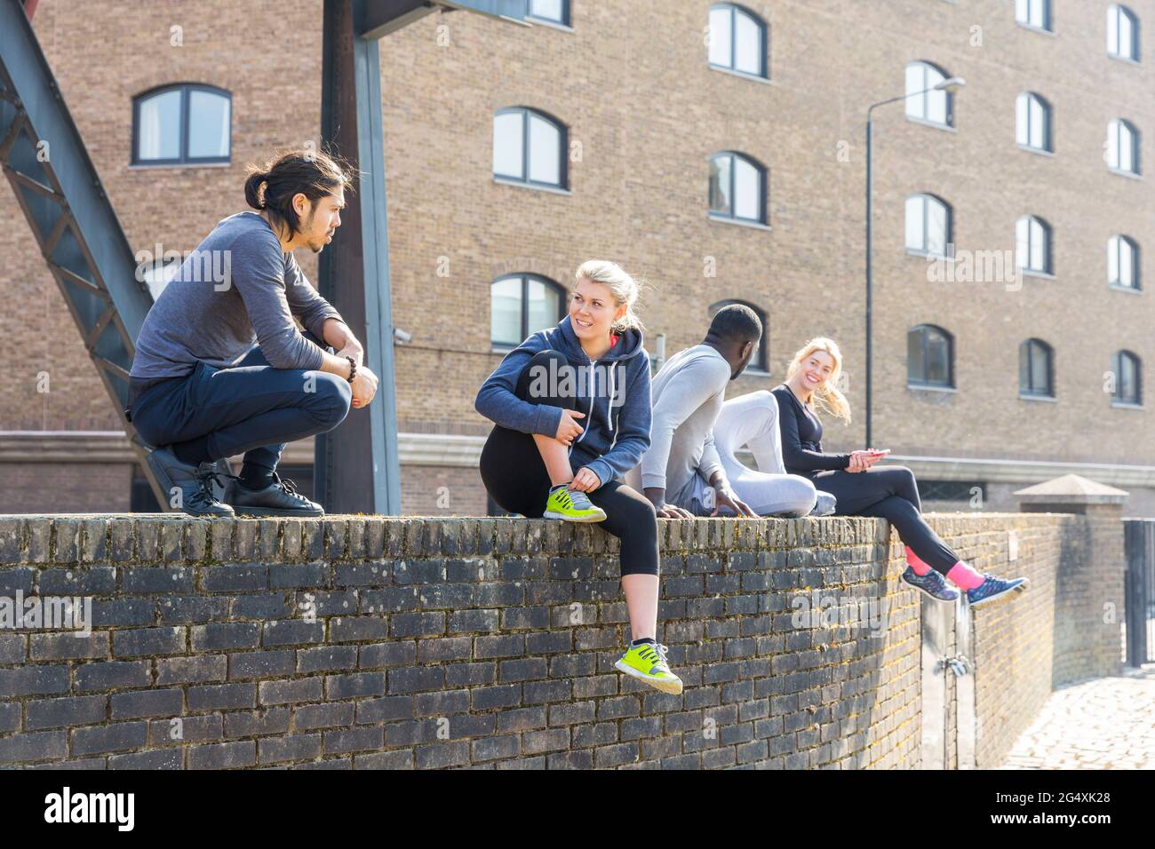 Group friends sitting on wall hi-res stock photography and images - Alamy