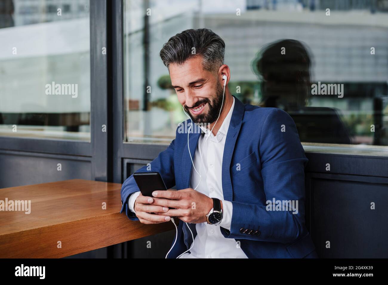 Male entrepreneur using mobile phone while sitting at cafeteria Stock Photo