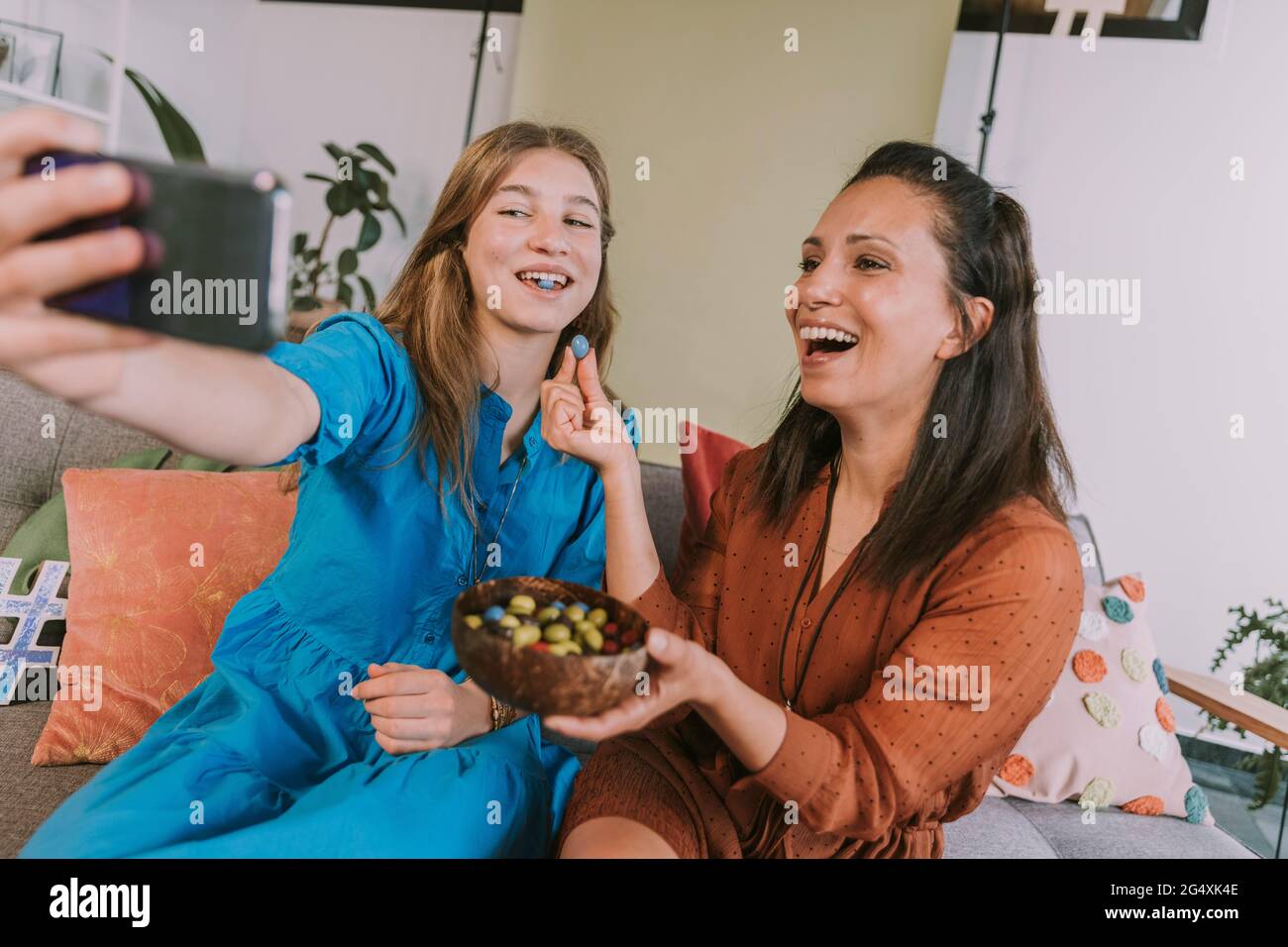 Women eating candies while filming at home Stock Photo