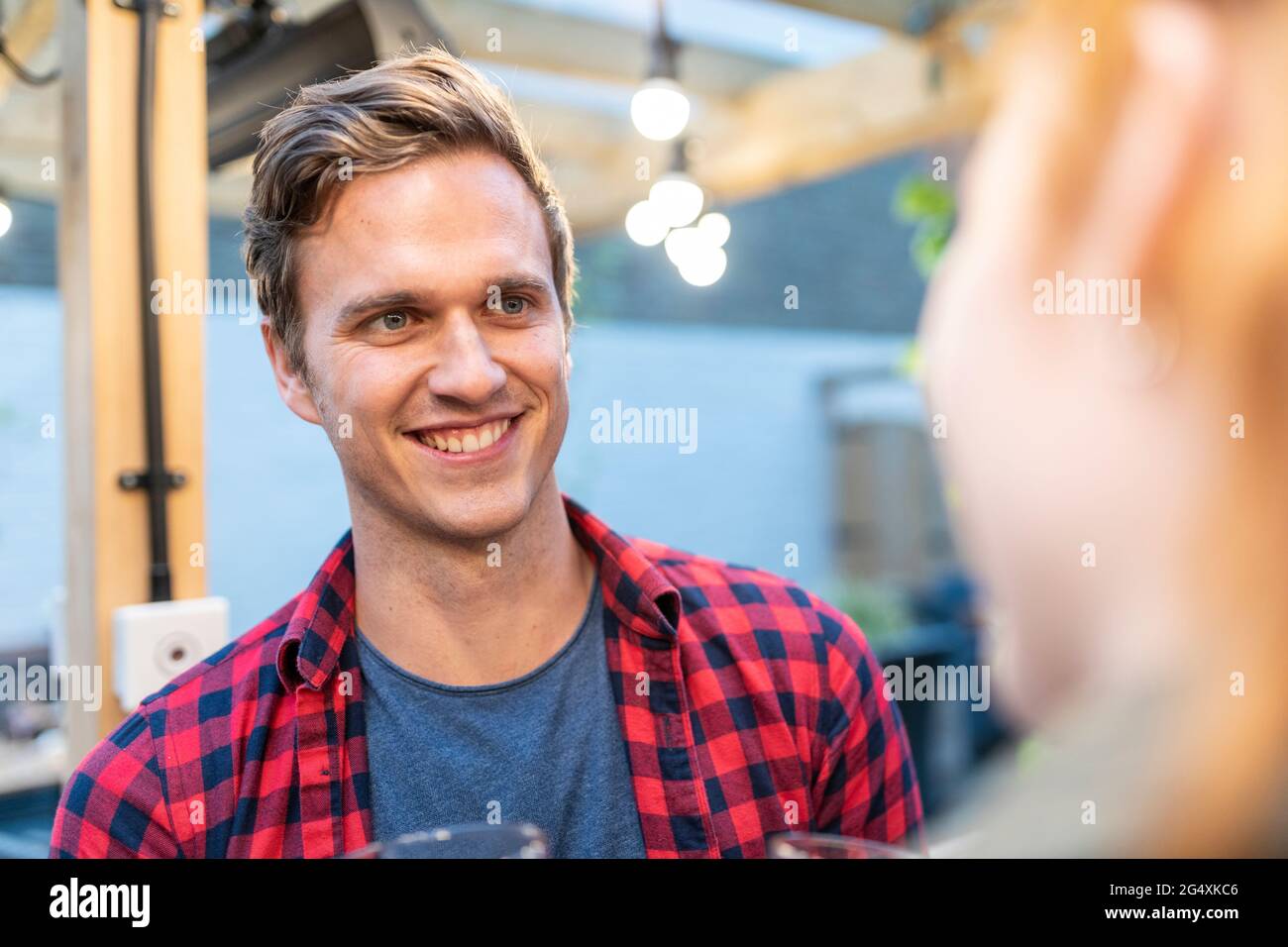 Smiling man in checked shirt at pub Stock Photo