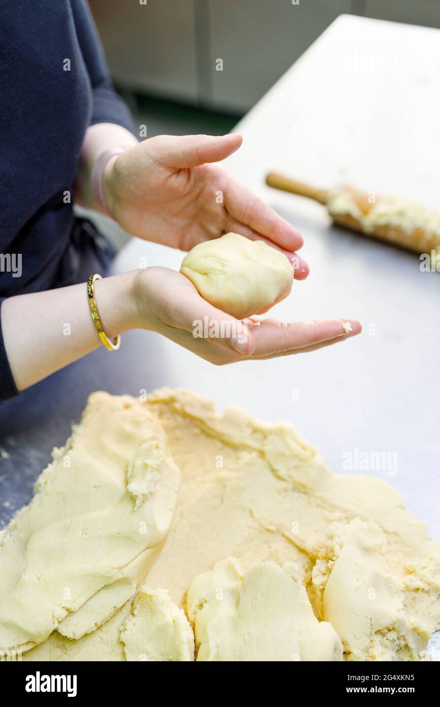 Female baker with dough working in bakery Stock Photo