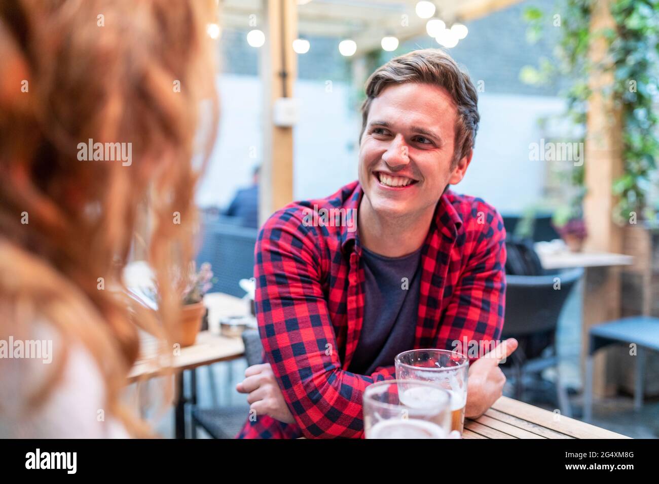 Smiling man looking at girlfriend in pub Stock Photo