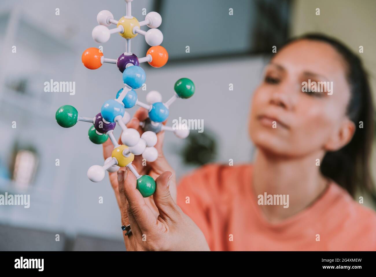 Woman looking at molecular structure Stock Photo